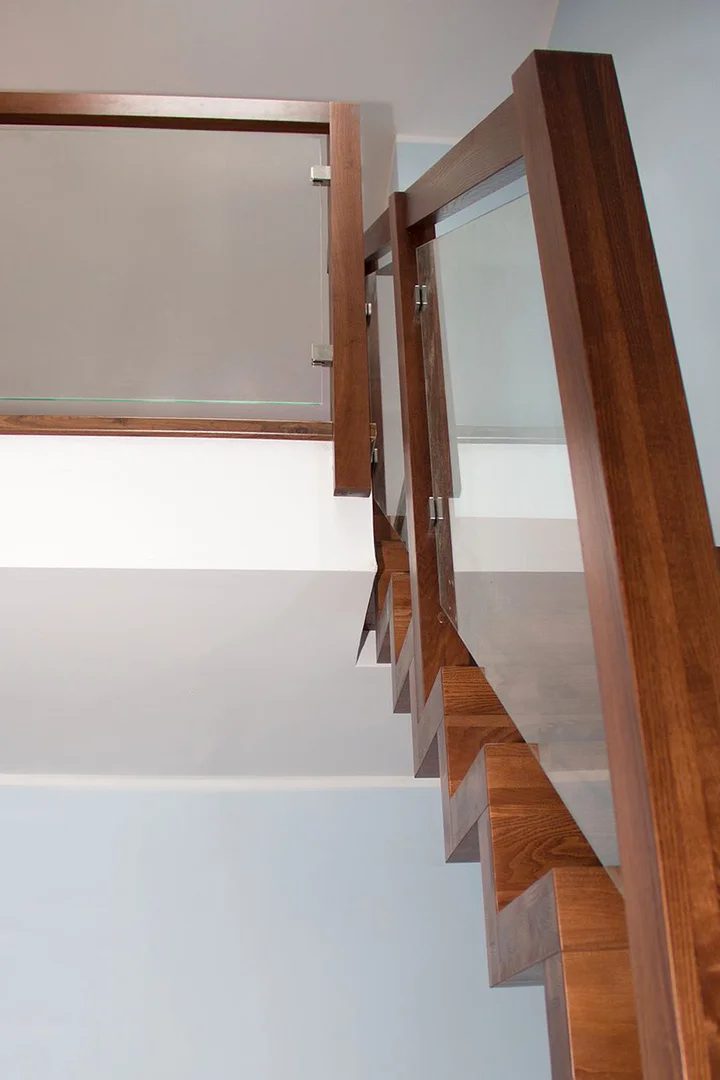 Nowoczesne schody dywanowe z jesionu, bejcowane, z balustradą szklaną Nowoczesne schody dywanowe z jesionu, bejcowane, z balustradą szklaną